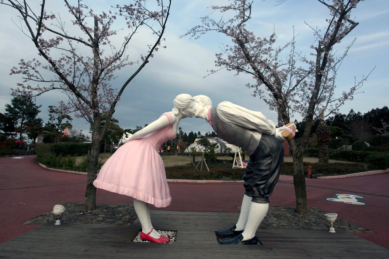 about-02 A sculpture of a couple kissing surrounded by cherry blossom trees in Love Land Park, South Korea.