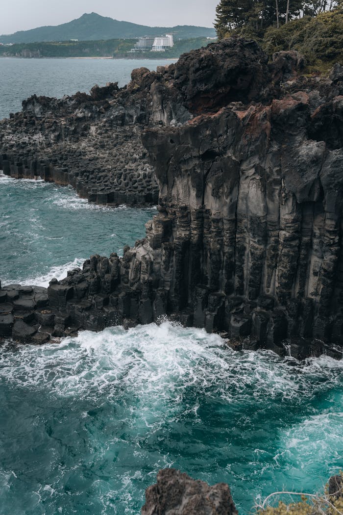 services-01 Dramatic cliffs and vibrant ocean waves at Jeju Island's stunning shoreline.