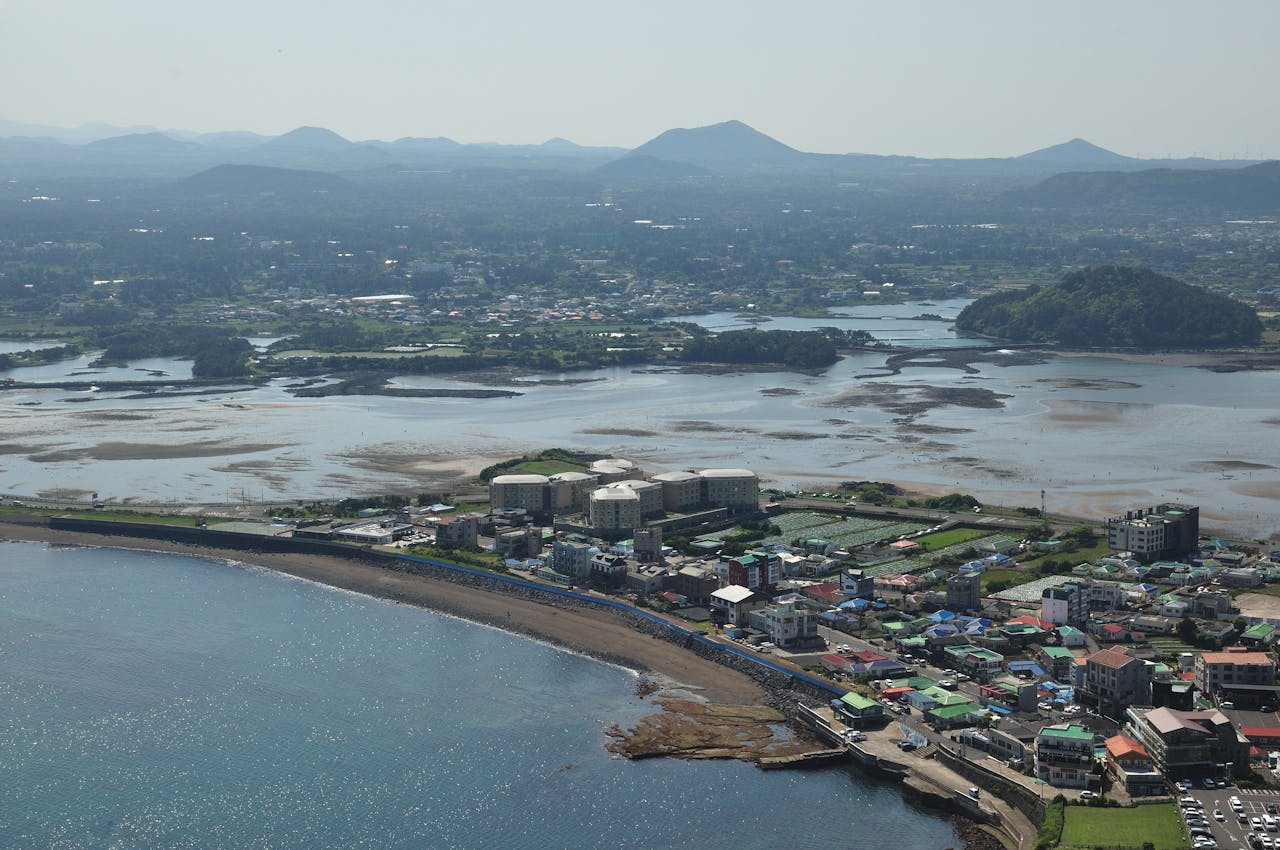 about-06 A stunning aerial photo capturing a coastal town in South Korea, with a mix of nature and architecture.