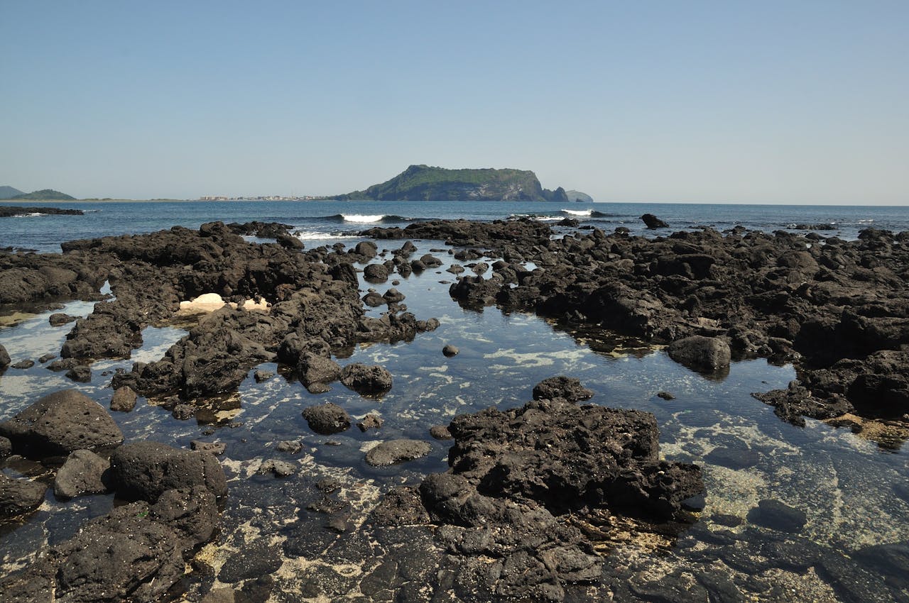 about-04 Scenic view of rugged black volcanic rocks along the coast of Jeju Island, South Korea.